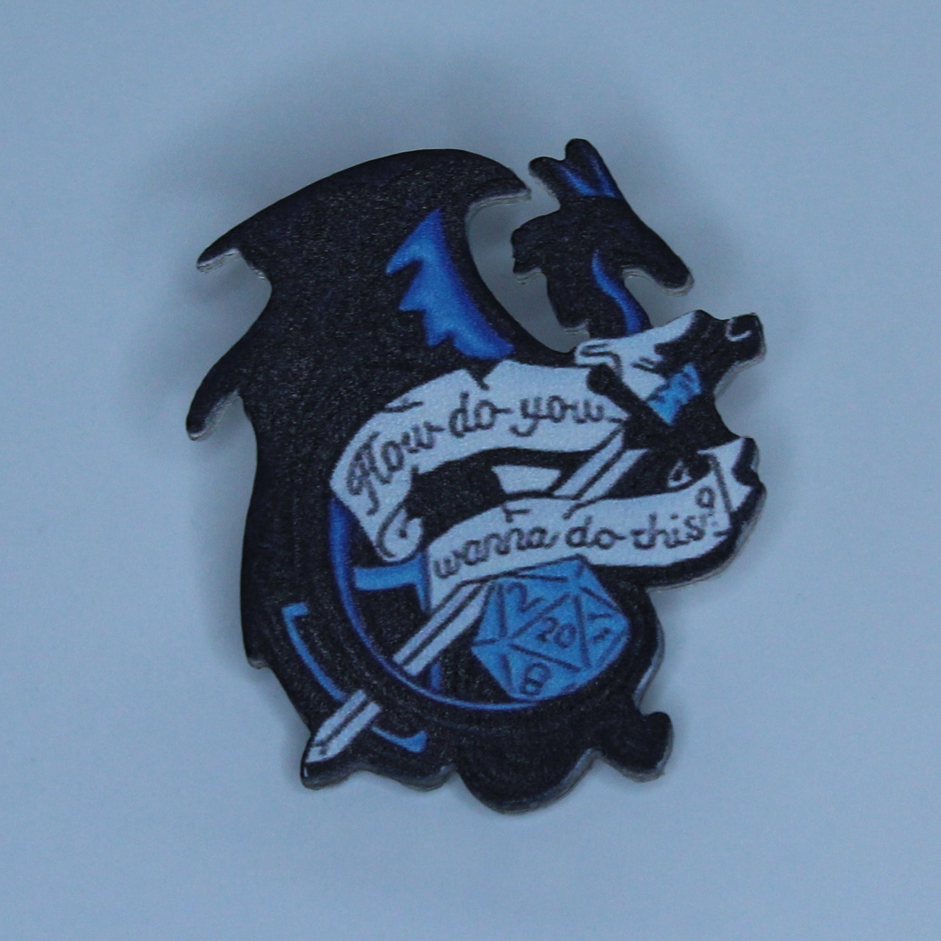 A small black acrylic pin shaped like a dragon holding a banner that reads 'I love you' and 'you are my love', with blue accents, centered on a light blue background.