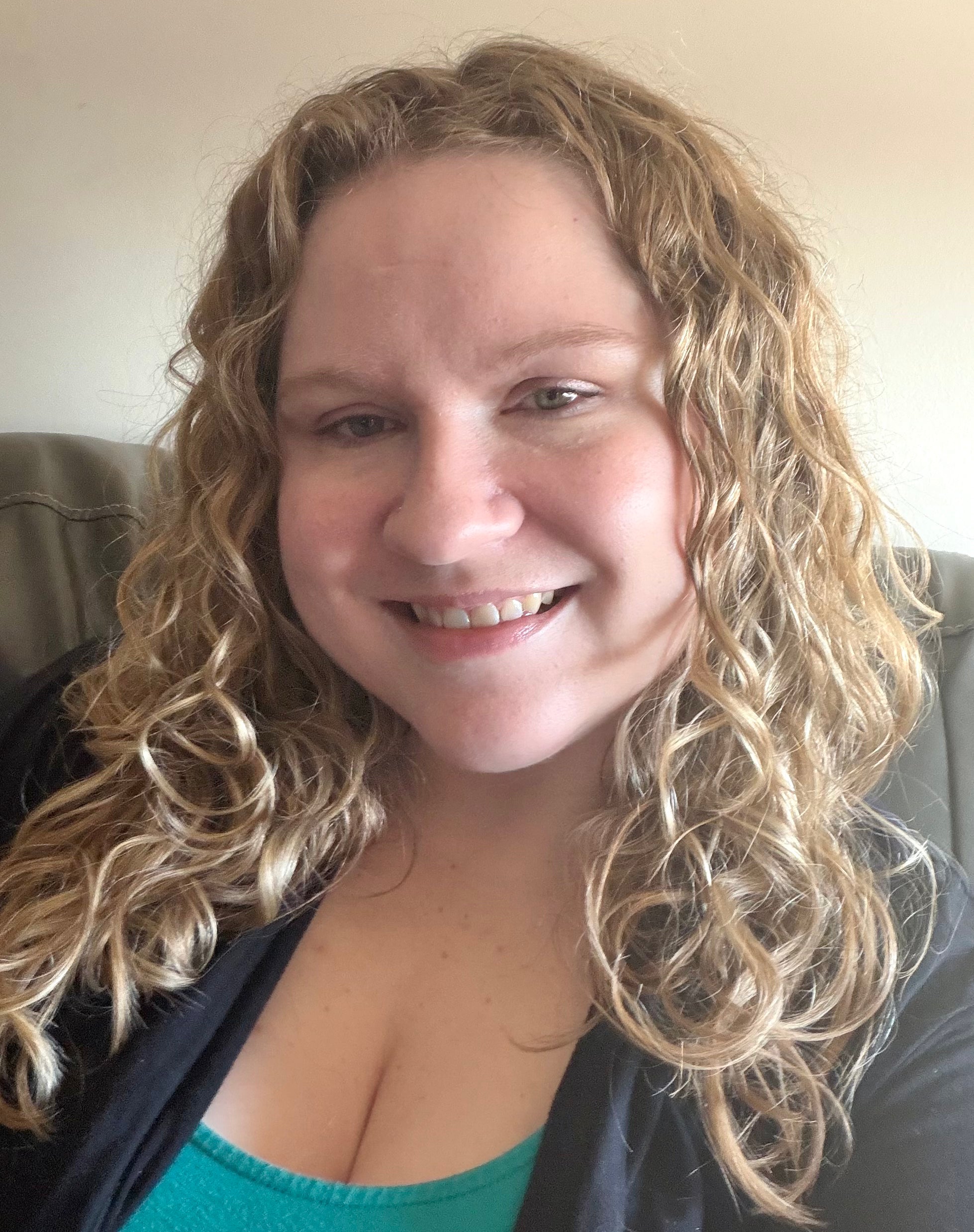Woman with curly blonde hair smiling at the camera