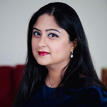 Woman with dark hair and red lipstick wearing a black top against a neutral background